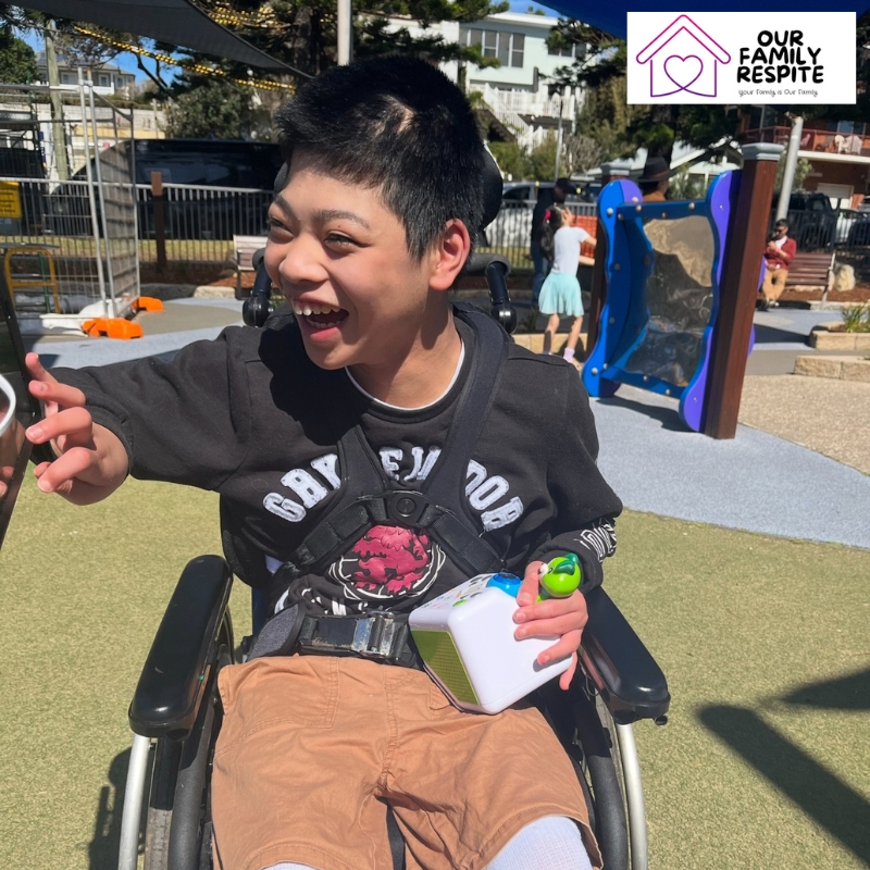 Child in a wheelchair playing in a park, symbolising support and freedom through emergency respite care services.