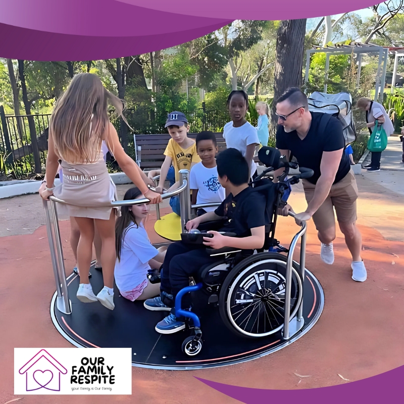 Children play on spinning playground equipment while an adult providing respite care assists in Lake Macquarie, amidst greenery and park facilities in a sunny outdoor setting.