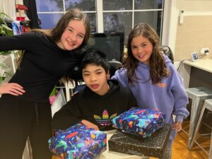 Children smiling together around a kitchen table, showcasing inclusive holiday activities through quality respite support