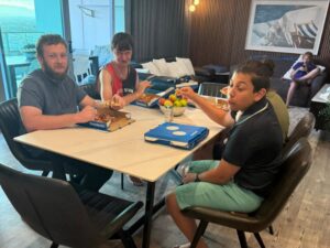 People sharing pizza around a dining table, accompanying an article on cultural needs during respite.